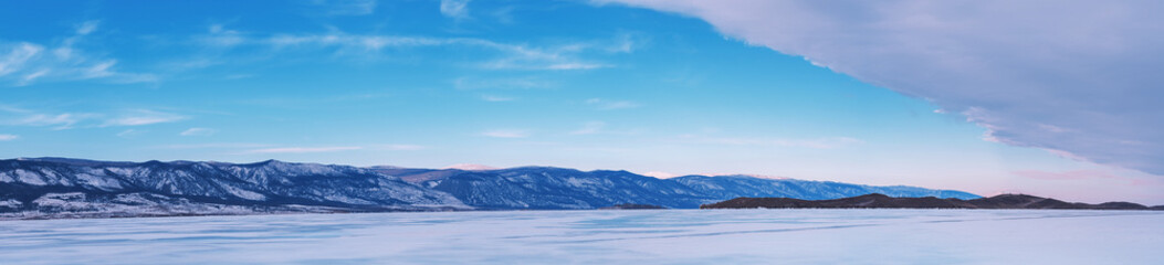 Beautiful winter landscape with mountains and Lake Baikal in Siberia at sunsut. Natural background with copy space. Web banner.