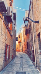 Old City Charm: Cobblestone Alley Bathed in Sunlight. Rustic Stone Buildings with History Etched in...