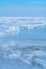 Ice hummocks against blue sky on Baikal Lake. Transparent blue ice floe. Great backdrop for your design with copy space.