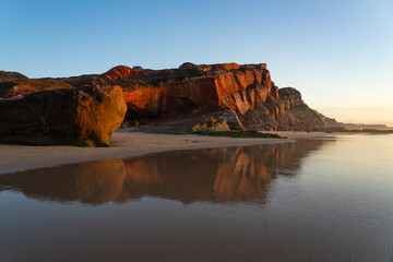 Multicolored sandstone rocks in the Almagreira beach in the Peniche area of the Center region of Portugal at sunset.