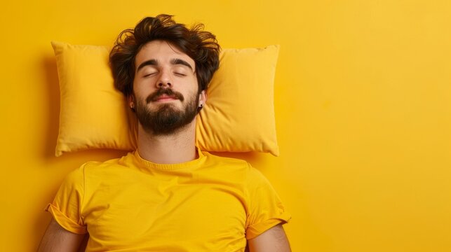 a young man sleeping on pillow isolated on pastel yellow colored background Sleep deeply peacefully rest. Top above high angle view photo portrait of satisfied .senior wear yellow shirt