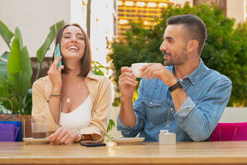 Happy woman talking on cell phone. a girl smiling using a mobile phone. Bride and groom on the terrace of a cafe