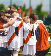 Kids With Coach in Sports Team. Friends on a Soccer Team. Male Football Players Huddling Together in a Circle Before a Match - obrazy, fototapety, plakaty