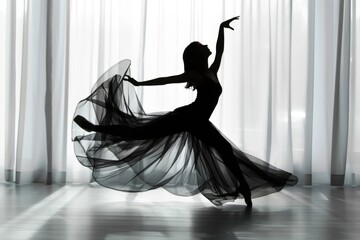 Fototapeta premium ballet dancer in silhouette, this time with a flowing skirt, mid-movement which accentuates the fluidity and dynamism of dance