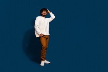 Full length photo of dreamy cool man wear white sweater holding modern gadget empty space isolated...