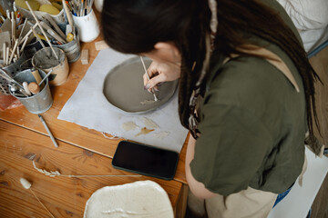 Caucasian creative woman working female ceramist making pottery in workshop