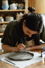 Caucasian creative woman working female ceramist making pottery in workshop