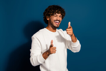 Photo of funny funky guy dressed white pullover winking eye pointing you two fingers isolated dark...