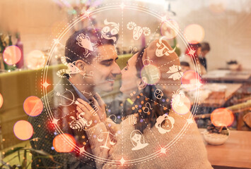 Happy young couple sitting in cafe on Christmas eve, view through glass window
