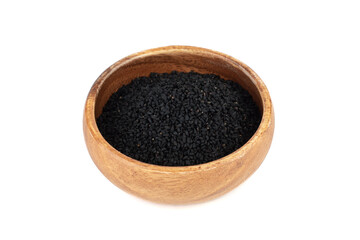 Wooden bowl with black sesame seeds on a white background.