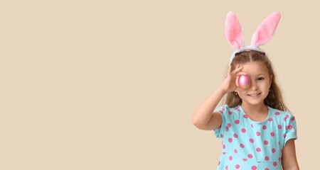 Obraz na płótnie Canvas Cute little girl in bunny ears and with Easter egg on light background with space for text