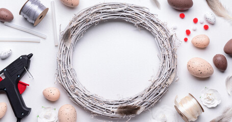 Composition with supplies for creating Easter wreath on white table