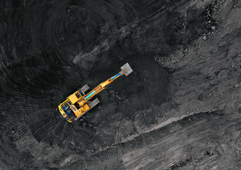 Coal mining in an open pit. Mining excavator loads coal in haul truck in quarry. Excavator digging in an open pit coal mine. Tipper truck hauling minerals from open-pit. Heavy machinery in opencast. © MaxSafaniuk