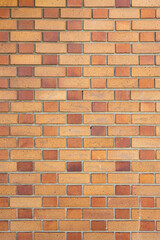 High resolution texture, pattern of yellow and brown brick wall structure as background. Brick masonry horizontal color technology architecture wallpaper. Vertical photo, close-up.