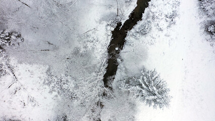 Aerial view of snowy winter landscape with small river. - 763204412