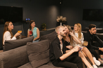 Group of students gathers in game room to play and drink. Friends immerse in friendly competition...