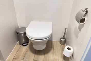 Toilet bowl. Interior of bathroom with Toilet bowl and with paper roll. White Ceramic toilet bowl.
