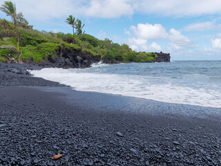 Landscape view of the amazing Honokalani Black Sand Beach in Waianapanapa State Park on the island...