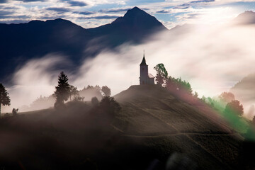 Jamnik, Slovenia - Magical foggy summer sunrise at Jamnik St.Primoz church.