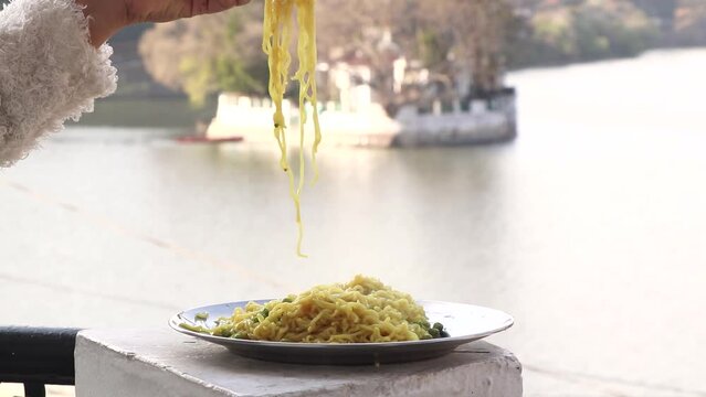 Footage of  noodles in front of a lake.its a selected focus video.