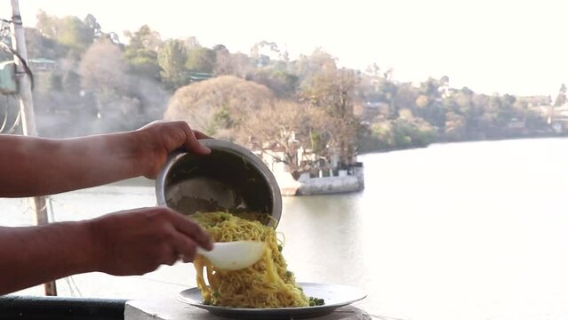 Footage of  noodles in front of a lake.its a selected focus video.