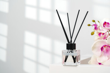 Elegant Reed Diffusers Beside Blooming Orchids in a Bright Interior Setting