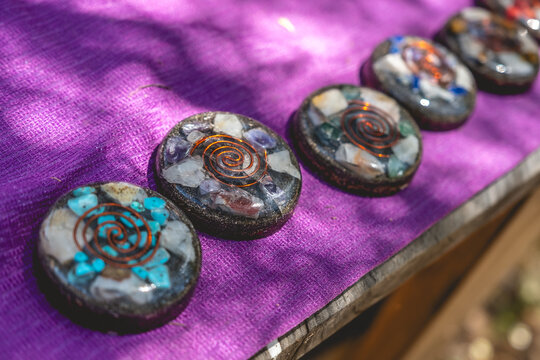 Natural protection: orgonite (orgon) discs, with quartz, metals and other compounds over a purple fabric under sunlight