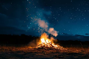 Fotobehang Crackling bonfire with smoke rising into a clear night sky filled with stars © furyon