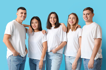 Group of young people in stylish jeans on blue background