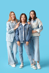 Obraz premium Young women in stylish jeans on blue background
