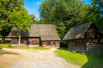 Fototapeta na wymiar Old wooden wallachia houses in old village with green meadow. Roznov pod Radhostem. Czech Republic.