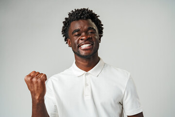 man in a white shirt is shown raising his fist in the air in a gesture of defiance or victory.