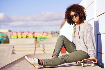 Sunglasses, smile and woman with skateboard in city by wall in summer for sport, leisure and relax...