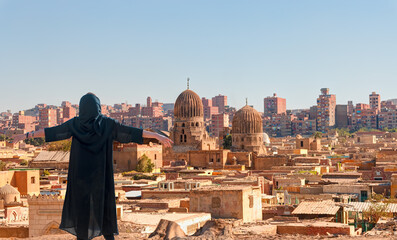 Beautiful girl wearing abaya with arms up happy - Old Necropolis “City of the Dead”, Cairo, Egypt