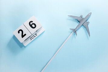 July calendar with number  26. Top view of a calendar with a flying passenger plane. Scheduler....