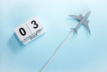 July calendar with number  3. Top view of a calendar with a flying passenger plane. Scheduler....