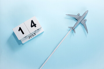 July calendar with number  14. Top view of a calendar with a flying passenger plane. Scheduler....