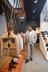 Fototapeta na wymiar Handsome young african man wearing suit in shop