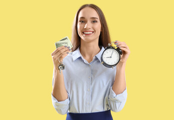 Portrait of female real estate agent with money and alarm clock on yellow background
