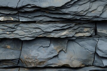 Close up of rugged and durable textured slate rock layers, stratified and natural, forming a detailed and abstract geological pattern