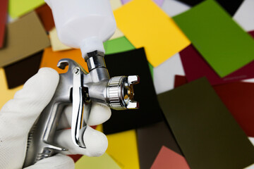 paint spray gun at work at the workplace in the workshop, selection of tools, paint samples