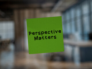 Post note on glass with 'Perspective Matters'.