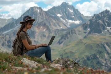 Naklejka premium Woman working on laptop in mountain landscape