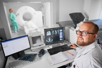 Fototapeta na wymiar Medical computed tomography or MRI scanner. Doctor smiling to camera, nurse making MRI. Specialists working in hospital, doctor examiing, studying results on computer. Concept of modern diagnostics.