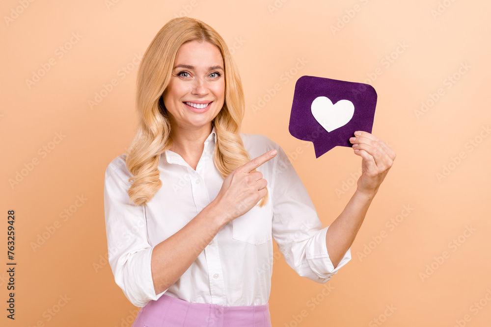 Sticker photo of charming cheerful lady dressed white shirt pointing finger feedback card isolated beige col