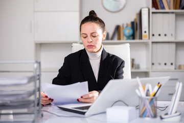 Successful business woman using laptop at workplace