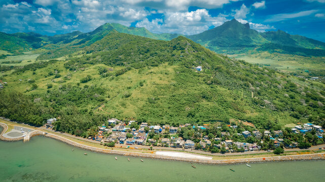 Aerial view of coastal village with sandy beach and turquoise lagoon, Grand Port Savanne, Mauritius.