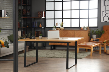 Interior of living room with workplace and bookshelf