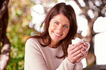 Portrait, smile and woman drinking coffee, cappuccino or espresso in backyard garden of home. Bokeh, morning and face of female person with cup of tea for relax, peace and happiness in nature