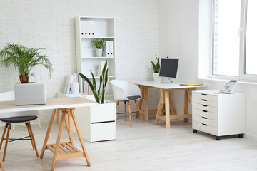 Interior of office with tables, shelf unit and plants